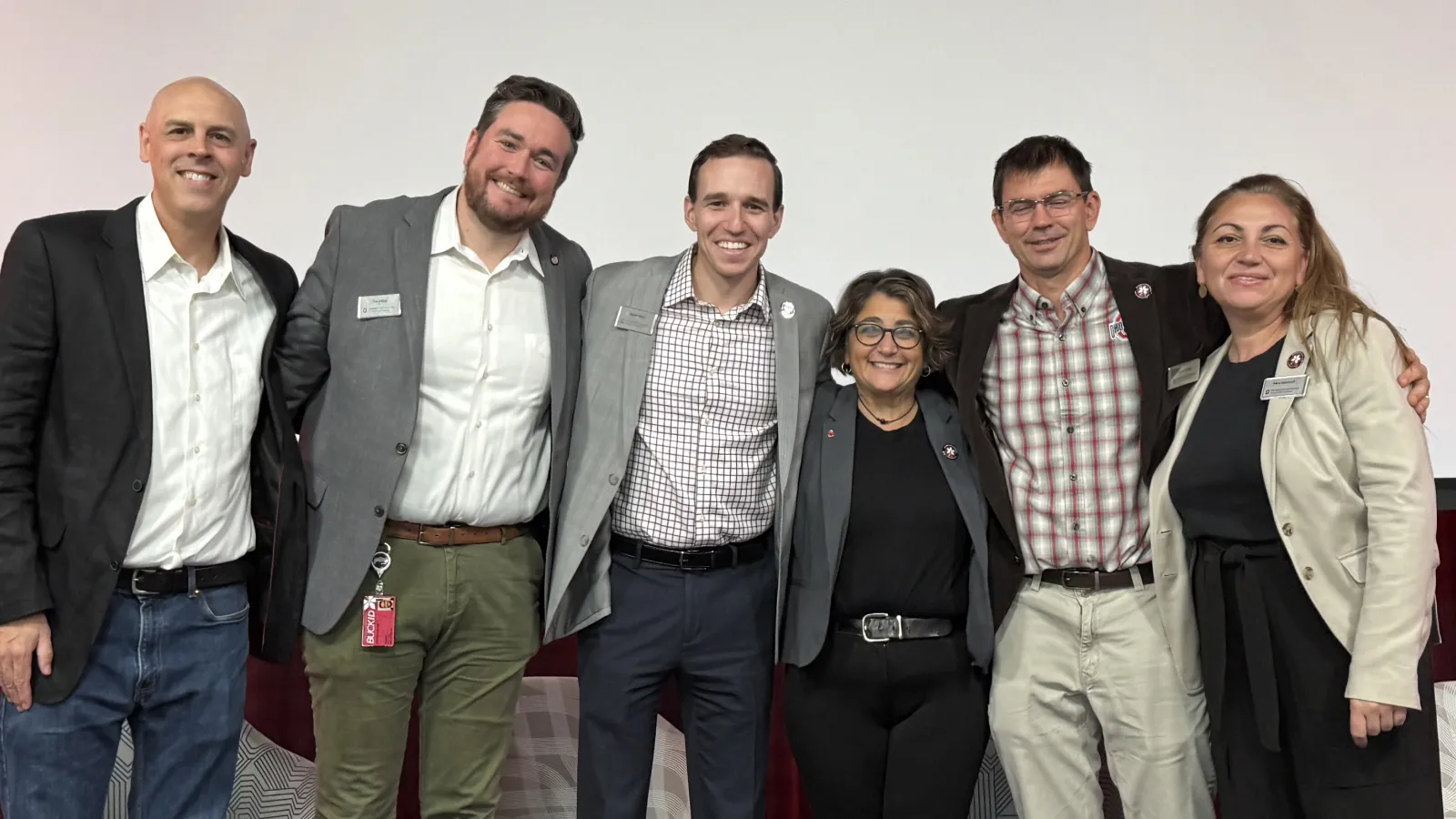 Five people smiling on stage